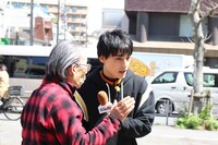 道行く人にインタビューするユースケ（右）。