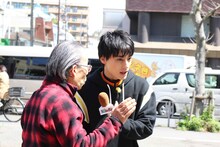 道行く人にインタビューするユースケ（右）。