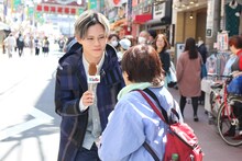 道行く人にインタビューするカイ。