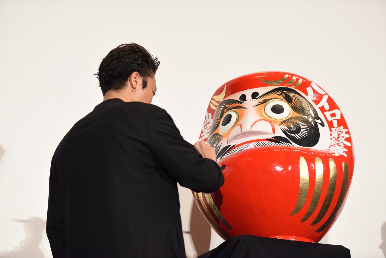 達磨に文字を入れるTAKAHIRO。