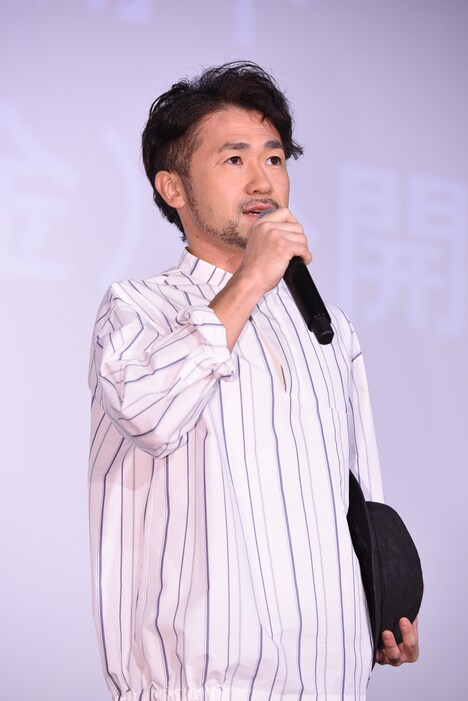 ハットを小脇に抱えたナオト・インティライミ。