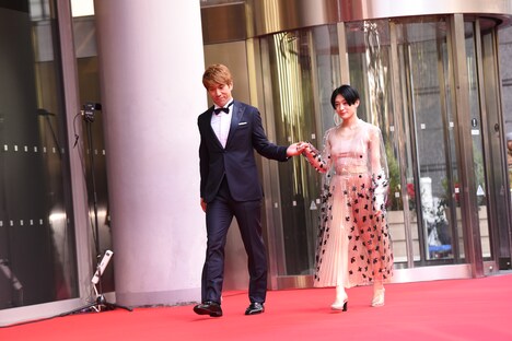 コムアイ（右）をエスコートするブリリアン・コージ（左）。