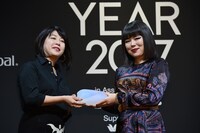 渡辺三津子編集長（左）からトロフィーを受け取るブルゾンちえみ（右）。