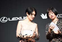 恩田陸とトロフィーの向きを確認するコムアイ（水曜日のカンパネラ）（左）。