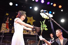 ダンサーから巨大なバラを受け取る星野みちる。