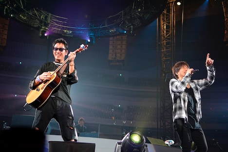 アコースティックギターを弾く黒田俊介と、ハンドマイクで歌う小渕健太郎。(写真提供:ワーナーミュージック・ジャパン)