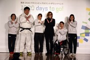 XポーズをするYOSHIKI(X JAPAN)とパラスポーツ選手たち。