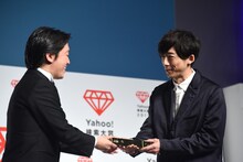 トロフィーを受け取った高橋一生（右）。