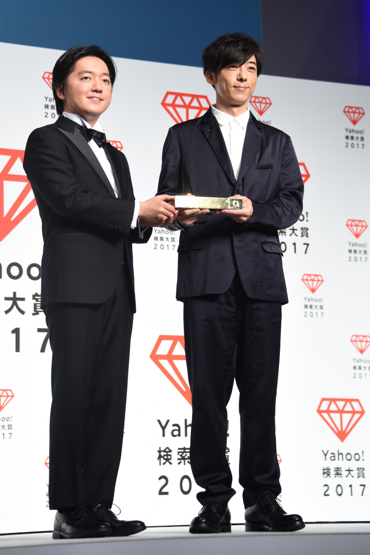トロフィーを受け取った高橋一生（右）。