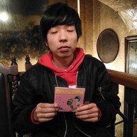 CDを手に持つ吉田靖直。