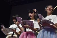 むすびーズからプレゼントされた冊子をうれしそうに眺める今井マイ、山田なみ、木村ミサ（左から）。