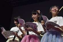 むすびーズからプレゼントされた冊子をうれしそうに眺める今井マイ、山田なみ、木村ミサ（左から）。