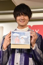 6月のページを見せて笑顔を浮かべる佐野勇斗。