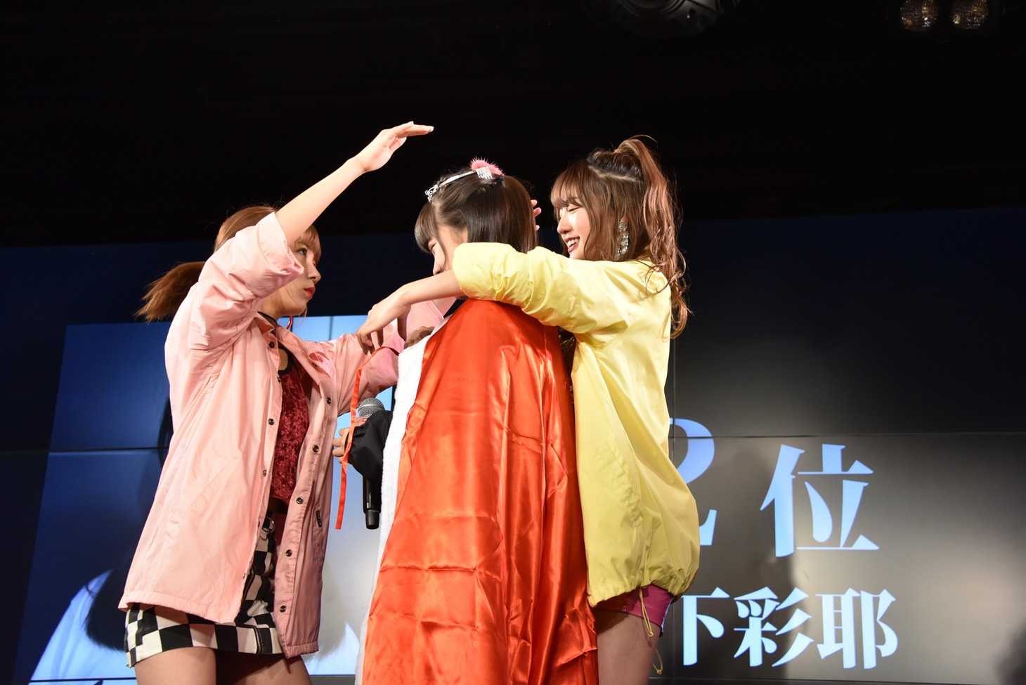 山下彩耶（中央）にティアラとマントを贈呈する荻野可鈴（左）と志田友美（右）。