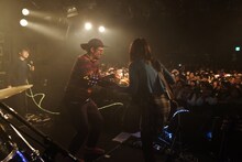 ケーキを運び込むYOUR SONG IS GOODのサイトウ "JxJx" ジュン（中央）。