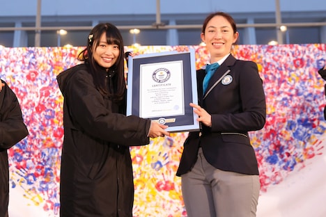 NGT48キャプテン北原里英（左）にギネス世界記録認定証明書を手渡すマクミラン舞氏（右）。 (c)AKS