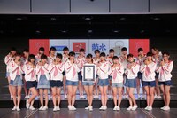 おにぎりとギネス世界記録認定証明書を手にほほえむNGT48。(c)AKS
