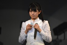 アイドルネッサンスの新ロゴで作られたキーホルダーを紹介する原田珠々華。