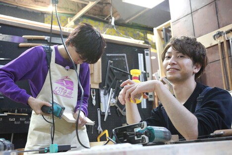 真剣に作業するリョウガ（左）と、6人の作業を見てニヤニヤするコーイチ（右）。