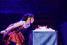 「7」型のバースデーケーキに立てられたろうそくの火を吹き消す水樹奈々。（撮影：上飯坂一）