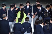 日本代表選手団から握手攻めにあうAI（中央）。