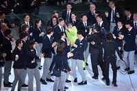 選手団の中に入って「ハピネス」を歌うAI。