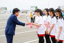 新潟商工会議所の福田勝之会頭からたすきを受け取るNGT48のメンバーたち。