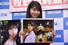 お気に入りのページを開く牧野真莉愛。ボールを持った後ろ向きのカットは「ナックルの握り」とのこと。