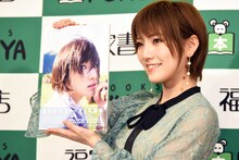 1st写真集「飾らない宝石」を持つ岡田奈々。