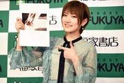 1st写真集「飾らない宝石」のお気に入りカットを指差す岡田奈々。