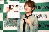 1st写真集「飾らない宝石」のお気に入りカットを指差す岡田奈々。