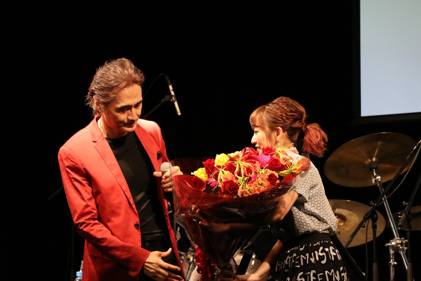 織田哲郎に花束を渡す高橋みなみ。