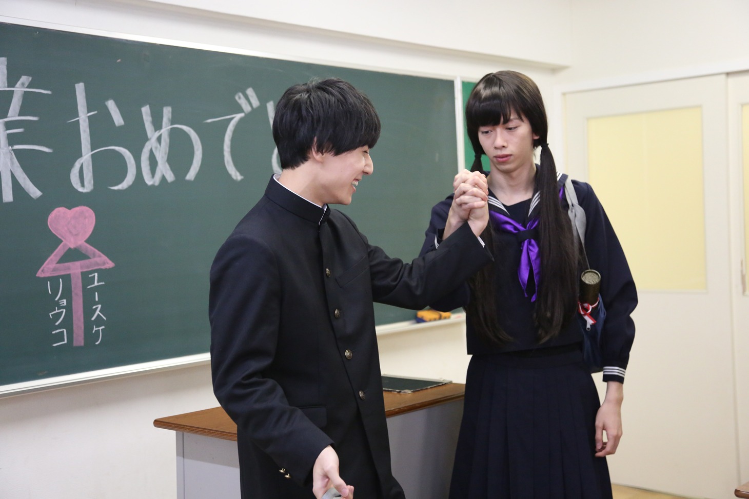 手をつなぐユースケとリョウコ（リョウガ）。