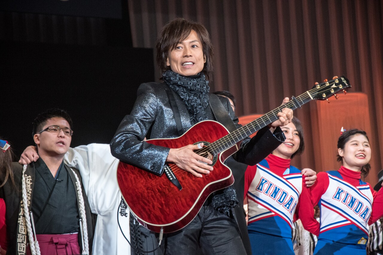 近畿大学校歌斉唱にギター伴奏で参加したつんく♂。（撮影：古川朋久）