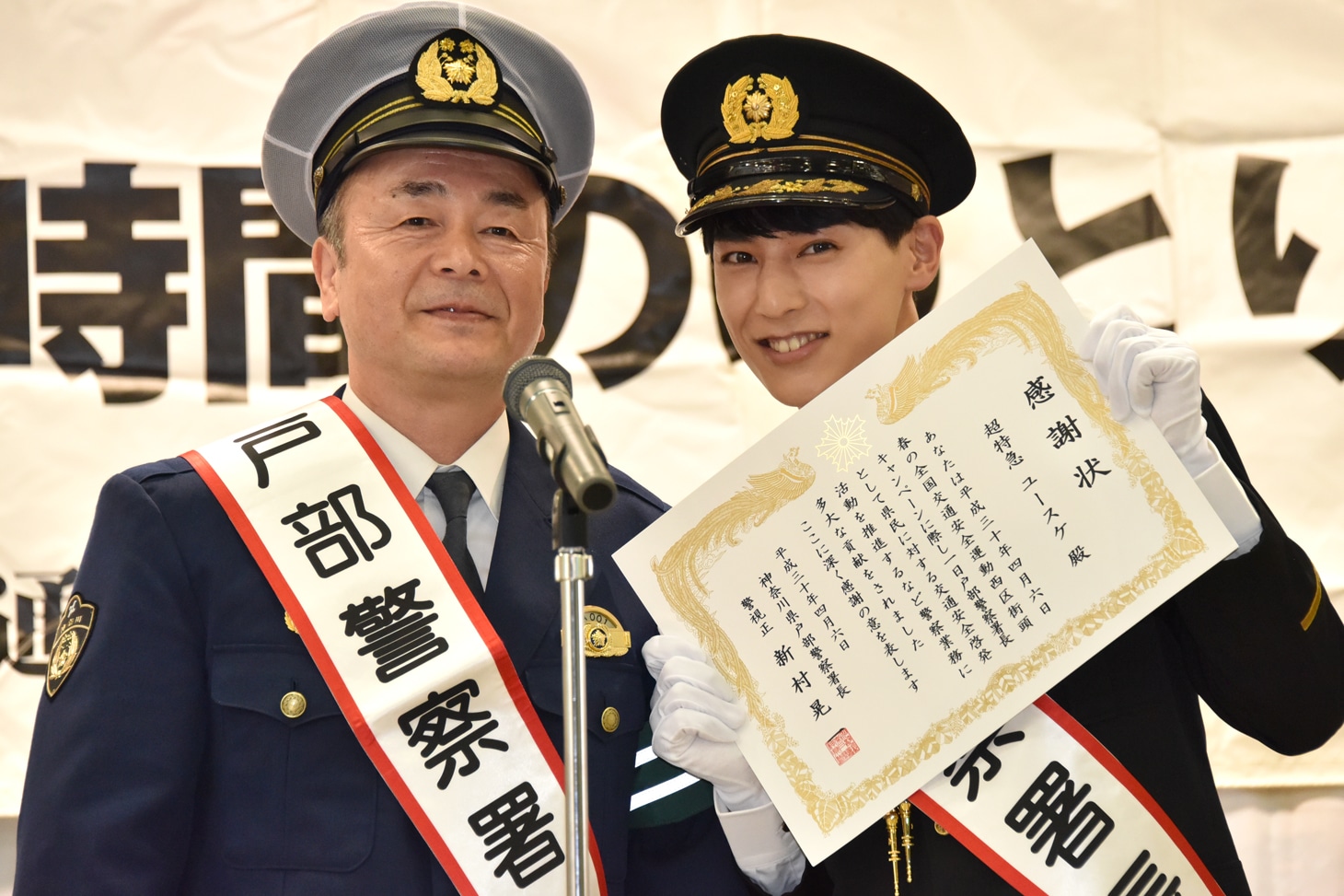 戸部警察署長（左）から感謝状を受け取ったユースケ署長（右）。