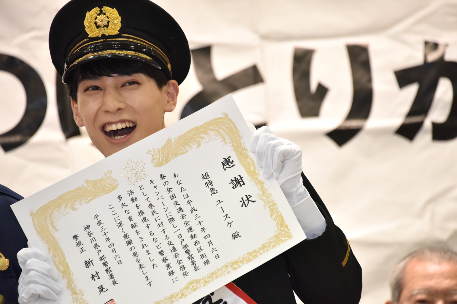 感謝状を受け取り笑顔のユースケ署長。