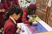 表参道・新潟館ネスパスの店内のポスターにサインを書き込むNGT48メンバー。