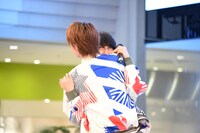 噴水前で末吉9太郎（奥）に抱きつくTAKA（手前）。