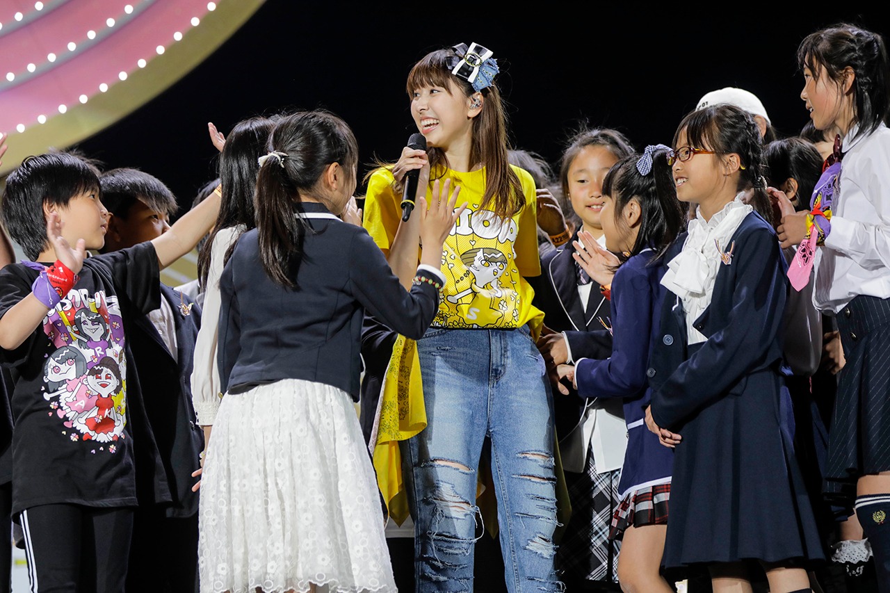 子供たちに囲まれて歌う玉井詩織。（Photo by HAJIME KAMIIISAKA+Z）