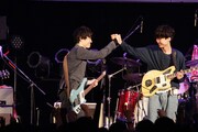 手を取り合う梅津拓也（B）と柴田隆浩（Vo, G）。