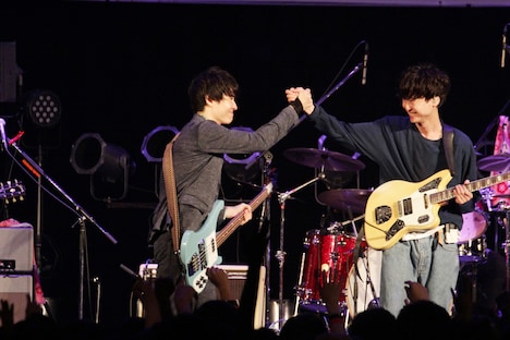 手を取り合う梅津拓也（B）と柴田隆浩（Vo, G）。