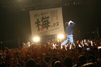 観客の上に立ってビールを一気飲みする柴田隆浩（Vo, G）。