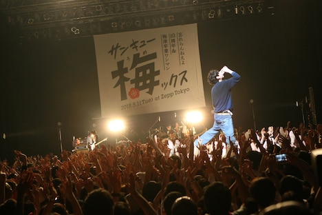 観客の上に立ってビールを一気飲みする柴田隆浩（Vo, G）。