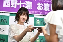ファンに1stフォトブック「わたしのこと」を手渡す西野七瀬。