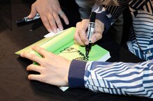 自著にサインをする河邉徹。