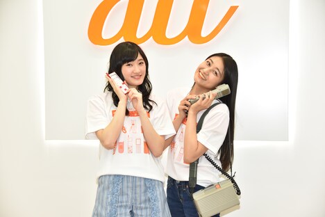 左からINFOBARを持つ川村文乃（アンジュルム）、ショルダーフォンを持つ和田彩花（アンジュルム）。