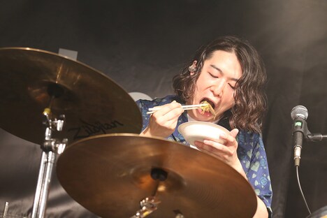 どじょう鍋を食べる鈴木敬（Dr, Cho）。（写真提供：ポニーキャニオン）