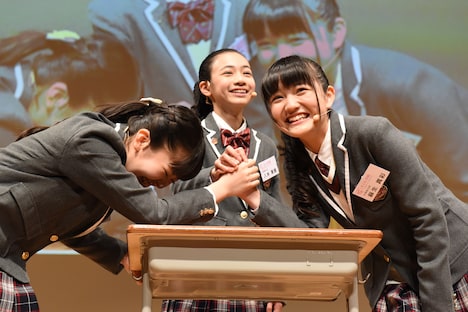 腕相撲をする森萌々穂と麻生真彩。レフェリーは八木美樹。