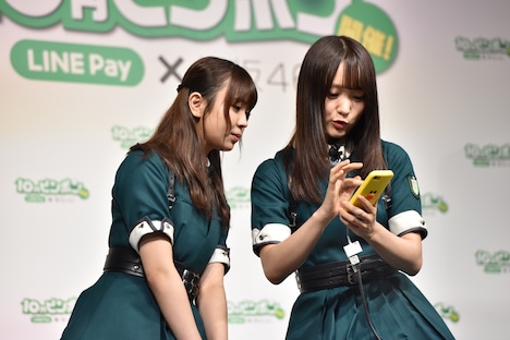 長濱ねるから10円を受け取った菅井友香（右）と小林由依（左）。