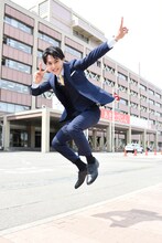 秋田県庁の前でジャンプするユースケ。